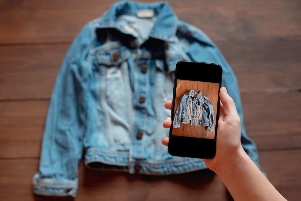 Person takes photo of second-hand denim jacket to list for sale online