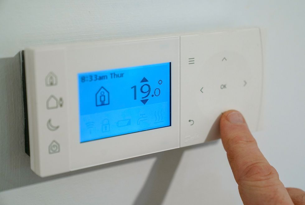 Person uses thermostat to keep warm