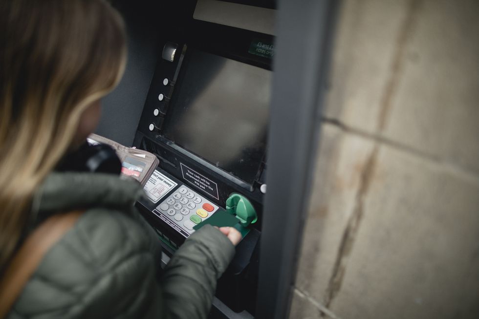 Person using ATM to withdraw cash