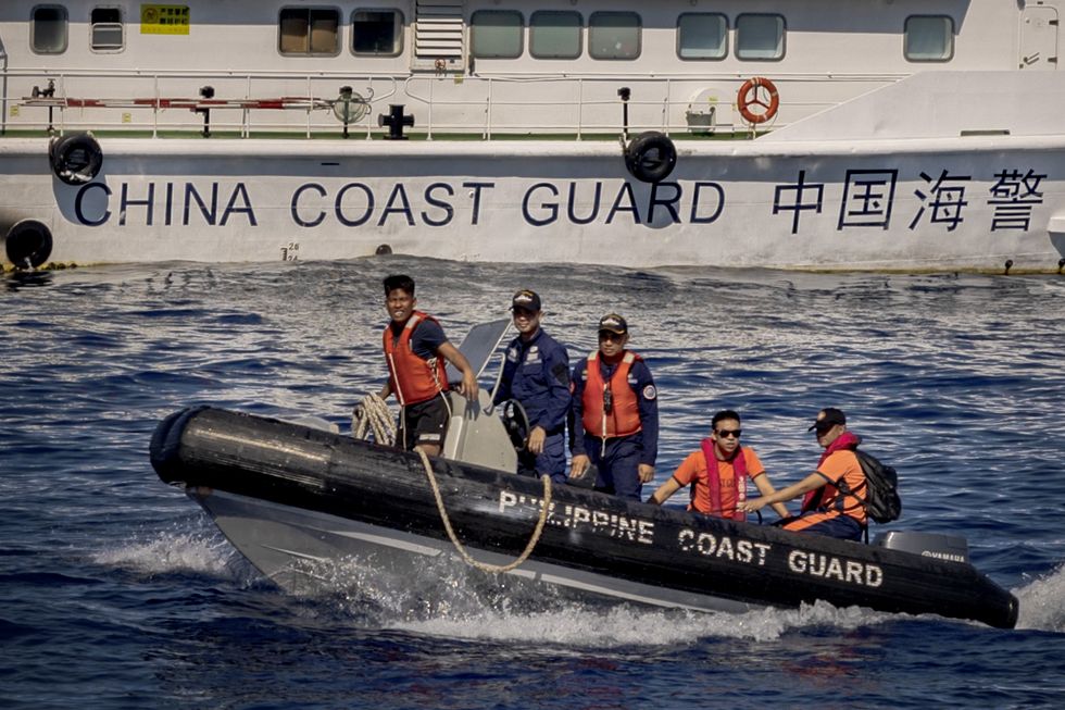 Philippine Coast Guard personnel ride a rubber boat