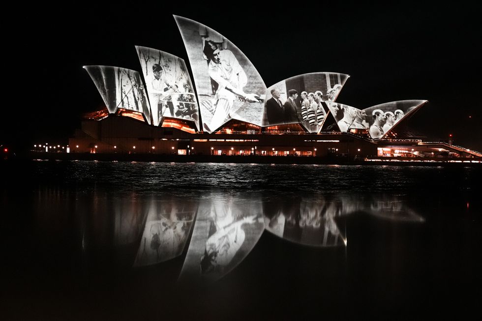 Pictures are projected onto Sydney Opera House, and reflected in a puddle on the harbourside, after King Charles III and Queen Camilla arrived in Sydney to begin their tour of Australia and Samoa