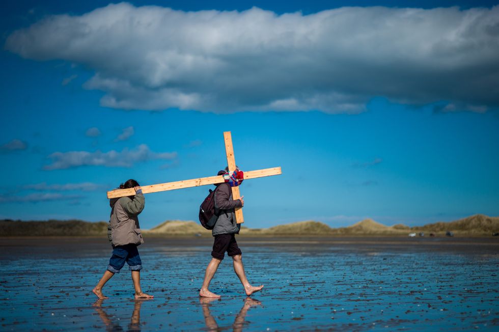 Pilgrims celebrate Easter by carrying wooden crosses as they walk over the tidal causeway to Lindisfarne during the final leg of their annual Good Friday pilgrimage