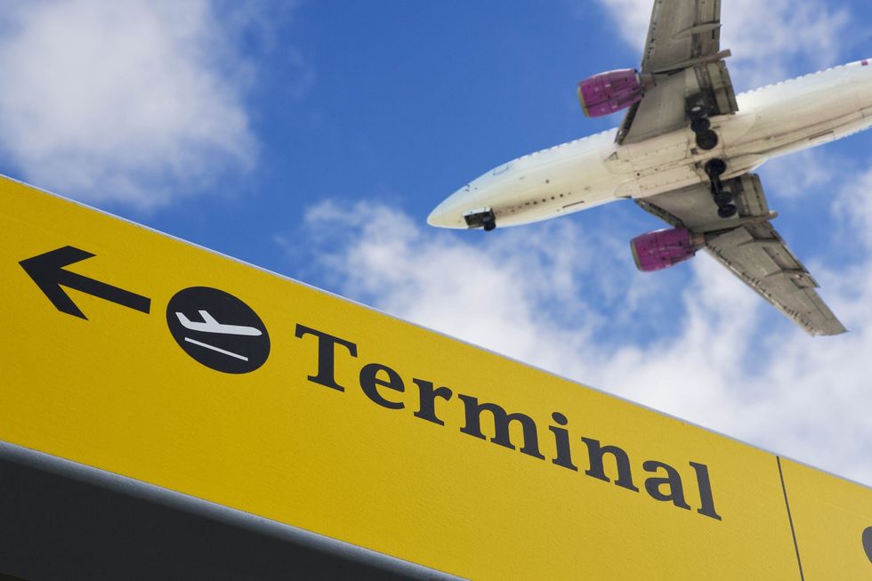 Plane flying over airport terminal sign