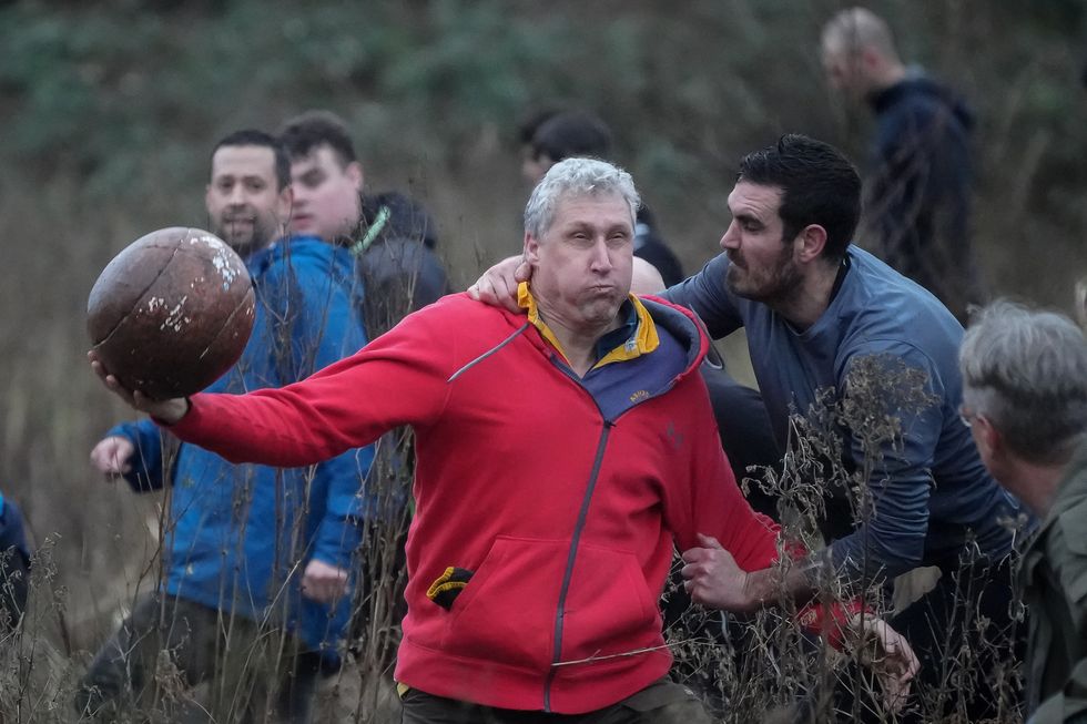 Players from the Up'ards and the Down'ards battle for the ball during the annual Royal Shrovetide Football Game on February 14, 2024 in Ashbourne, England