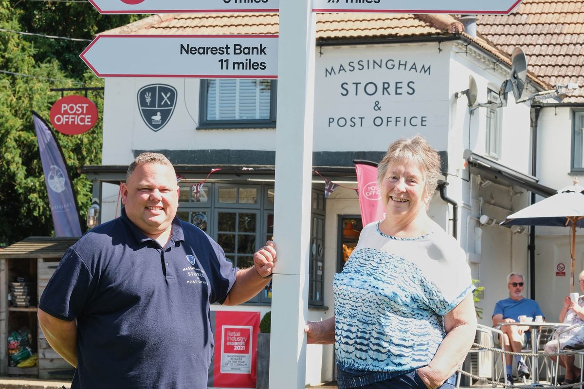 Post Office postmaster and Great Massingham resident Eddie Evans by sign pointing to nearest bank branches