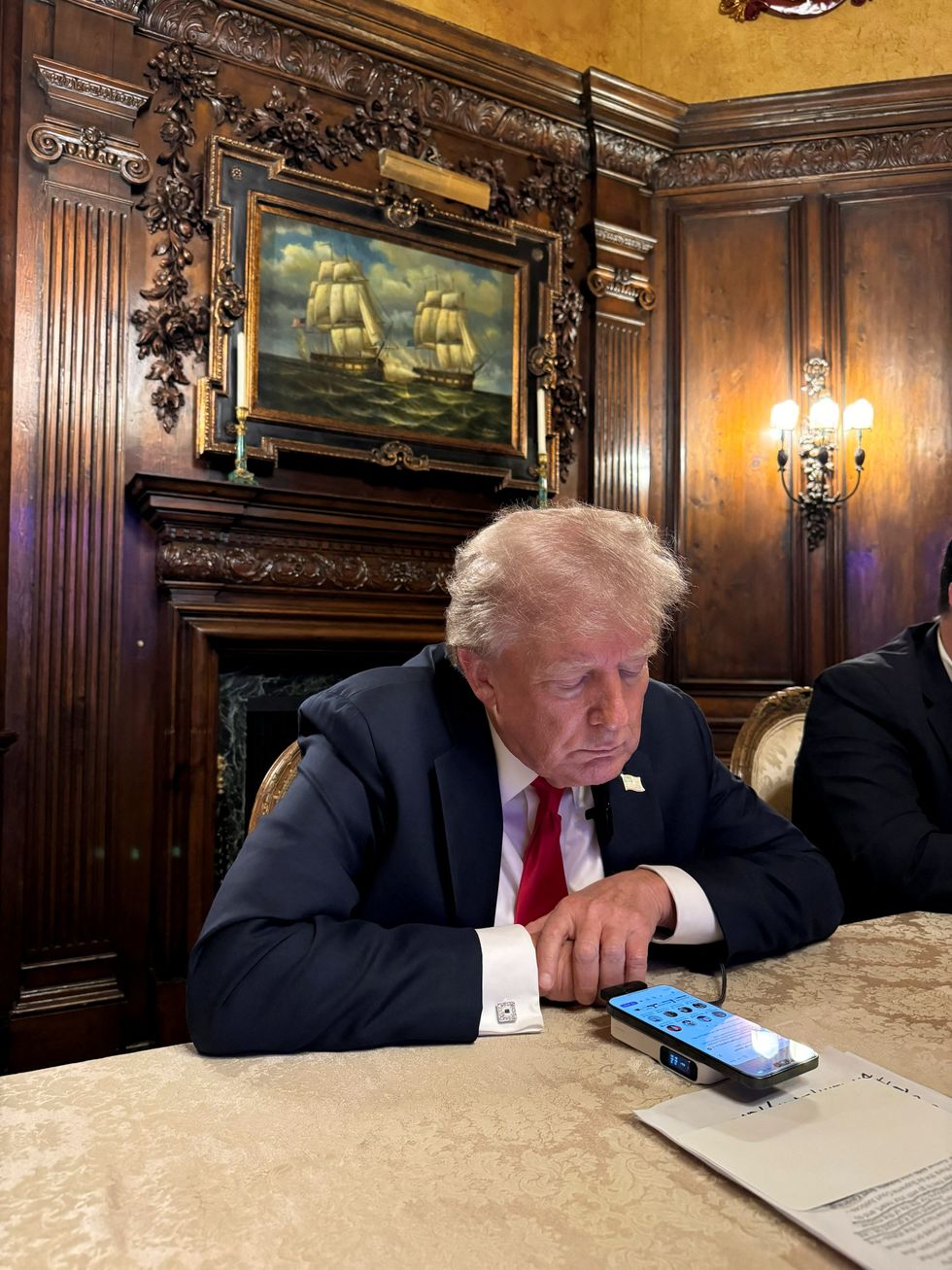 president donald j trump speaks to elon musk from a table in florida