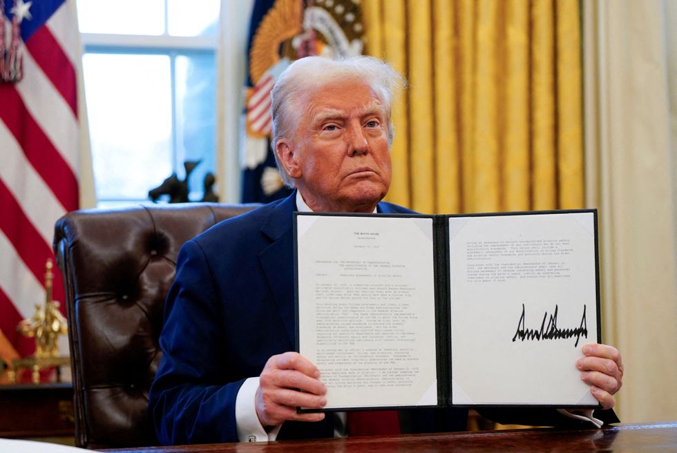 President Donald Trump holds up an executive order entitled 'Immediate Assessment of Aviation Safety'