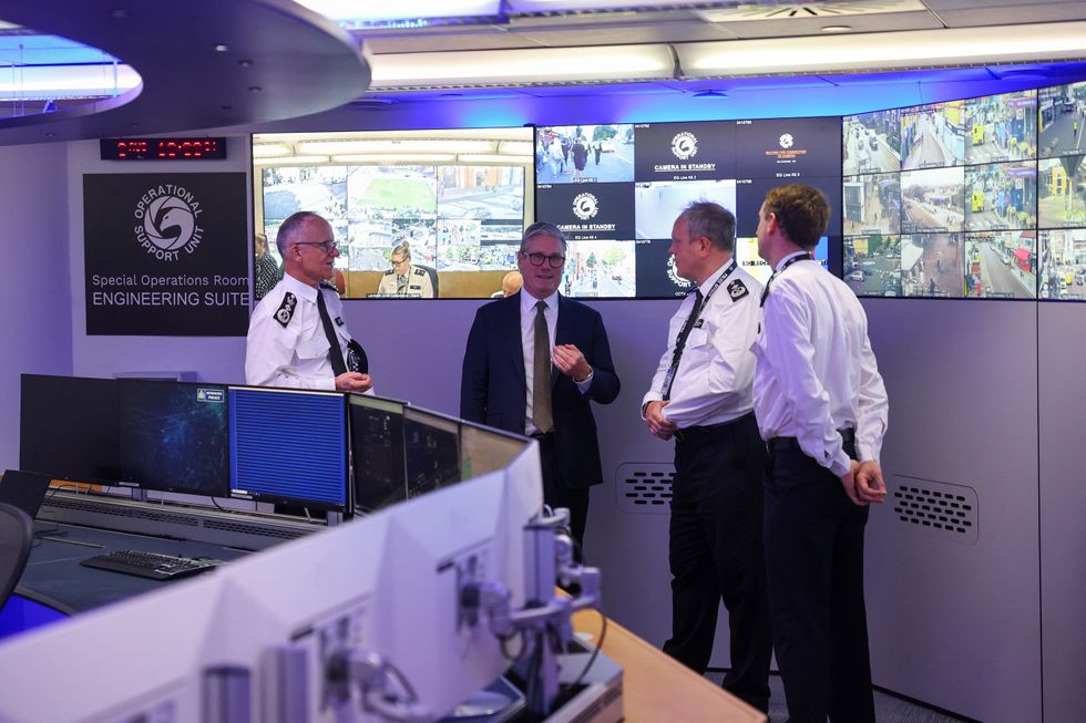 Prime Minister Keir Starmer speaks with Metropolitan Police Commissioner Mark Rowley, Metropolitan Police Deputy Assistant Commissioner Andy Valentine and Commander Ben Russell beside CCTV