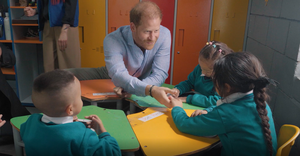 Prince Harry shaking hands with children