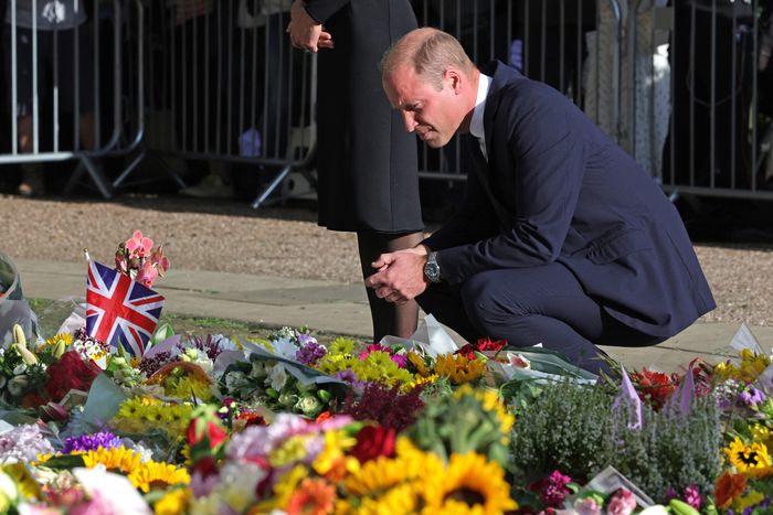 Prince William looks at flowers for his grandmother the Queen
