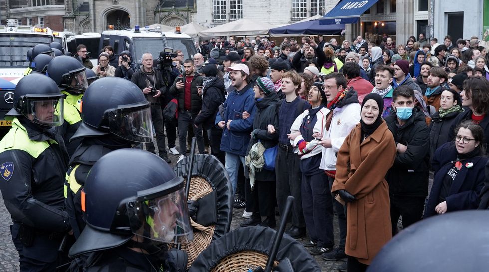 Pro-Palestinian protesters face Dutch police during a banned demonstration in Amsterdam