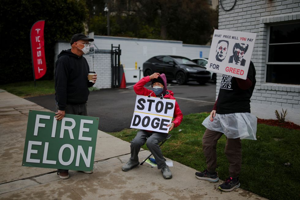 Protesters criticising Elon Musk and DOGE outside a Tesla dealership