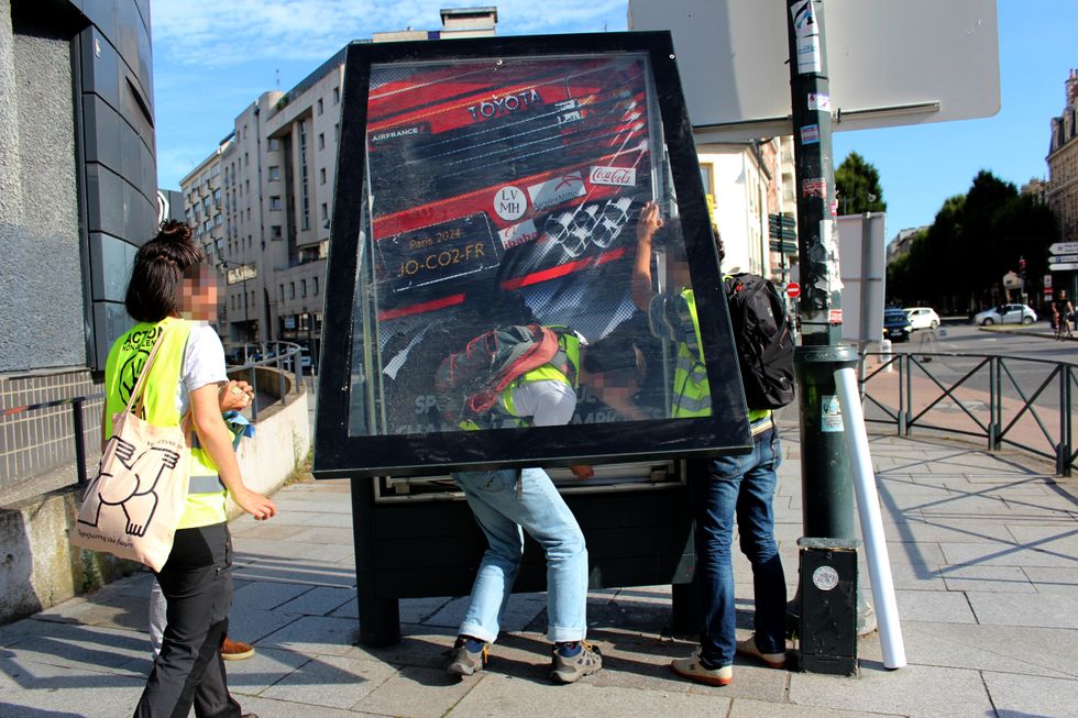 Protestors installing a Brandalism poster