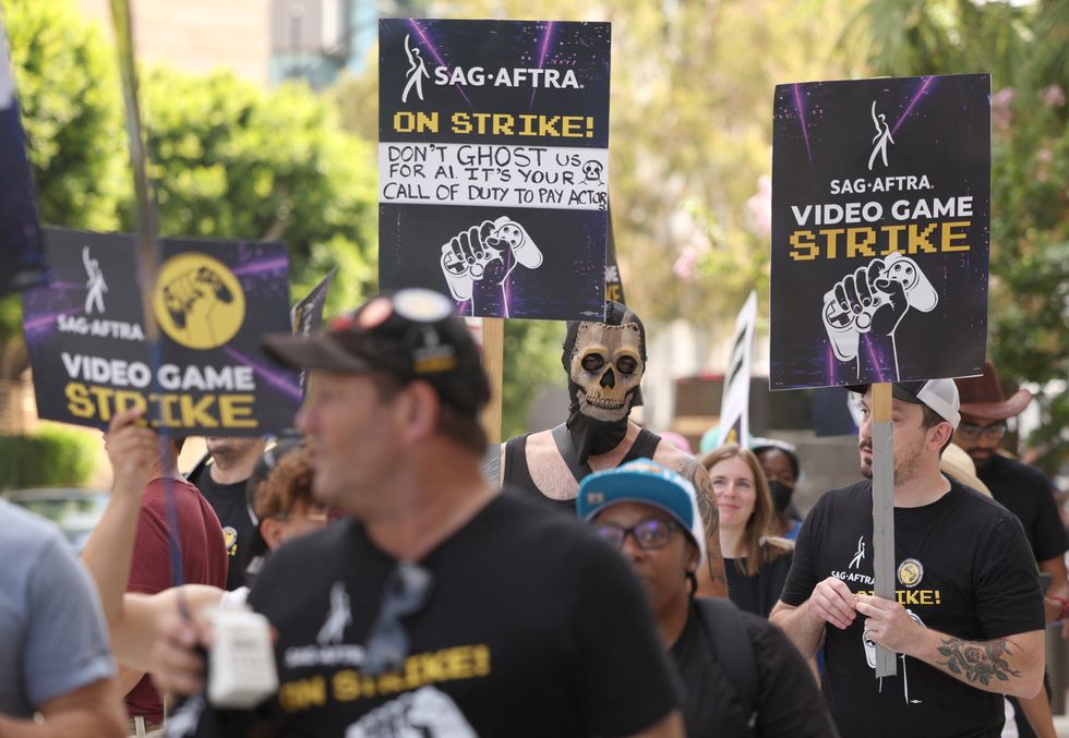 protestors standing outside of warner bros for the video game strike with placards