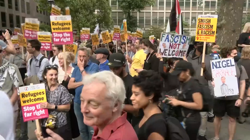 'Refugees welcome - stop the far right' placards are held aloft