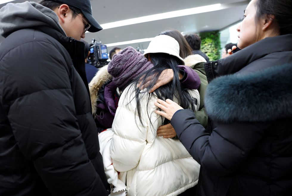 Relatives of a passenger of the aircraft that crashed after it went off the runway, react at Muan International Airport