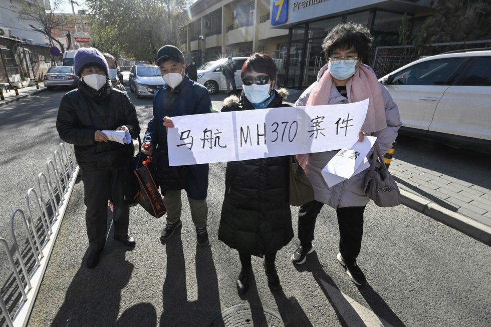 Relatives of passengers of the missing Malaysia Airlines flight MH370 hold a sign