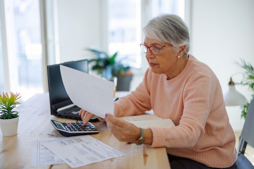 Saver looks at calculator and statement