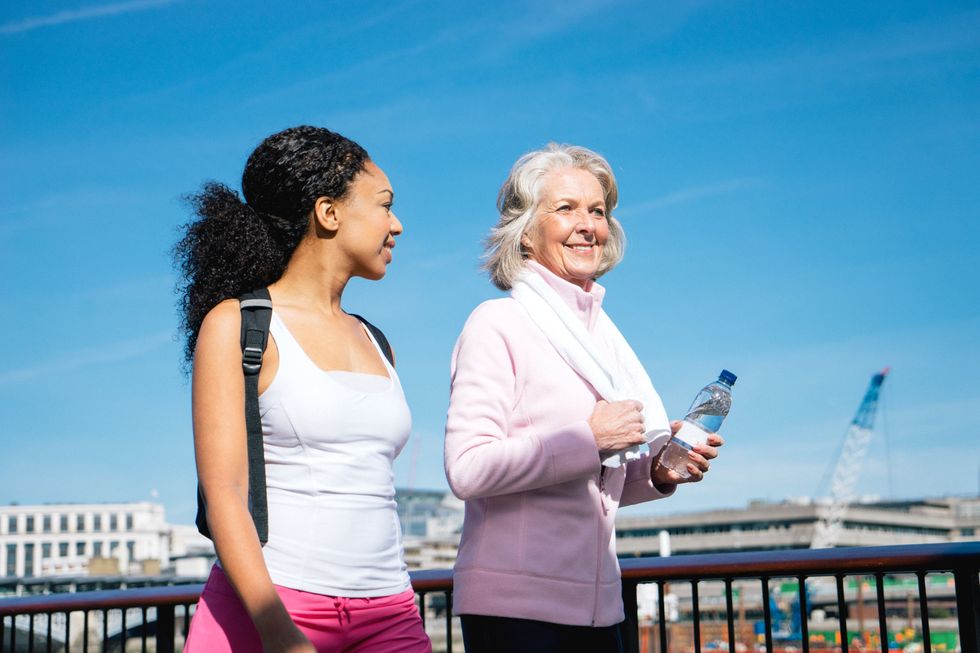 Senior woman and young woman walking together