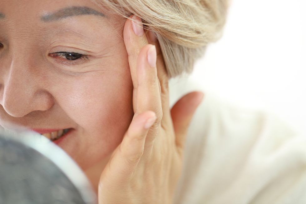 senior woman applying skin care