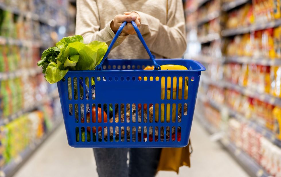 Shopper holding basket in supermarket