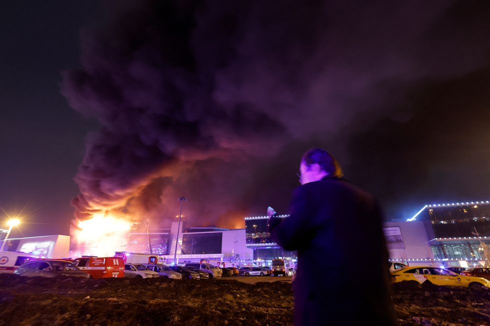 Smoke from fire rises above the burning Crocus City Hall concert venue following a shooting incident, outside Moscow