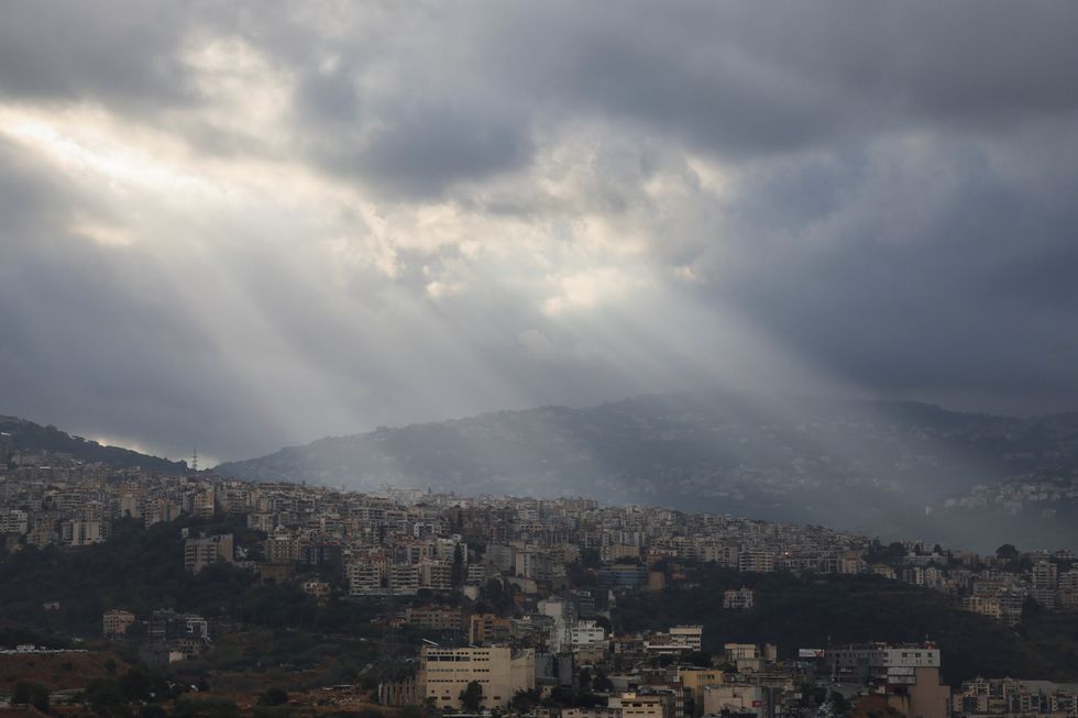 Sunlight illuminates through the clouds over the mountains and Beirut's southern suburbs following heavy rainfall, amid the ongoing hostilities between Hezbollah and Israeli forces\u200b