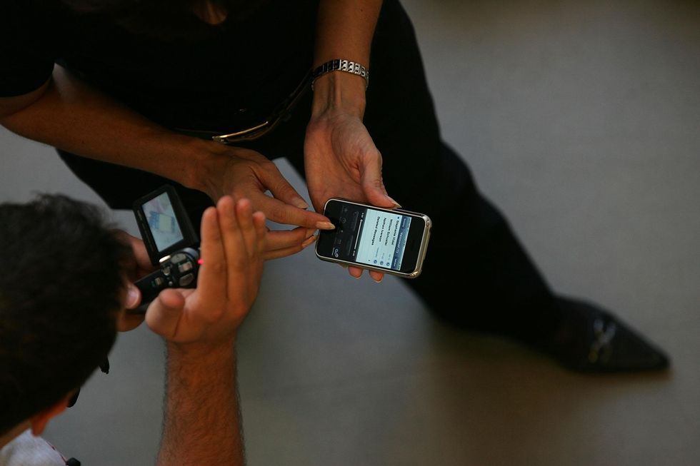 The new Apple iPhone is demonstrated to a customer at the unveiling in their flagship store on Regents Street, London