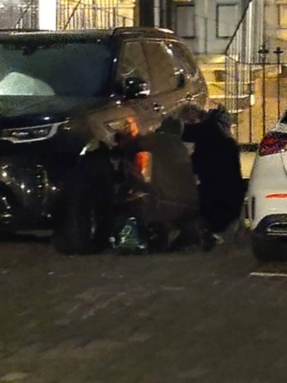 Two protesters defacing an SUV in Edinburgh