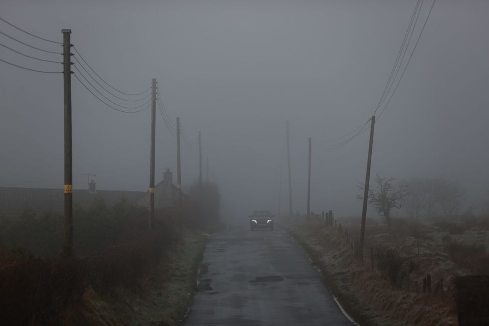 \u200bA car drives through thick fog on Tornaroy Road outside Belfast