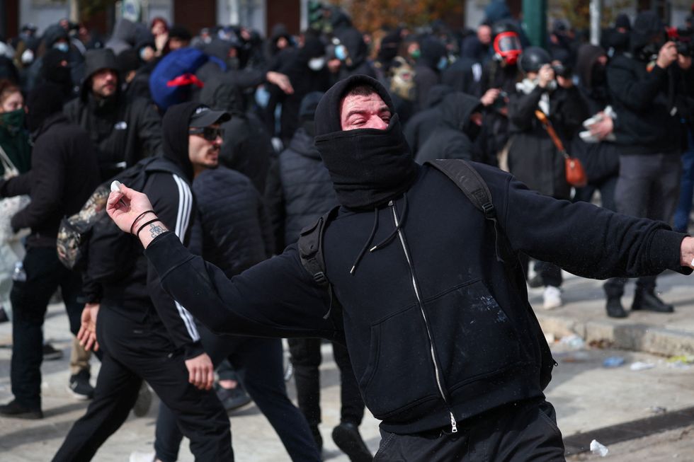 u200bA demonstrator prepares to throw an object during a protest by the Greek parliament