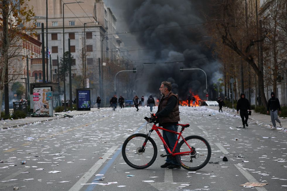 u200bA  fire burns during clashes with riot police outside the Greek parliament