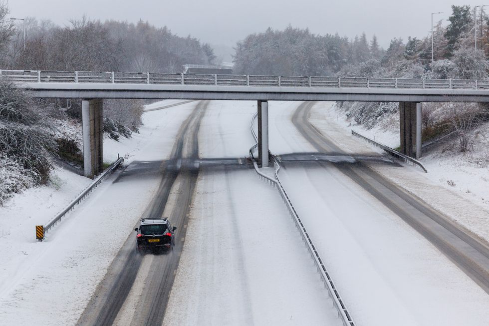 u200bA lone vehicle is driven along the snow covered M9 motorway near Stirling.