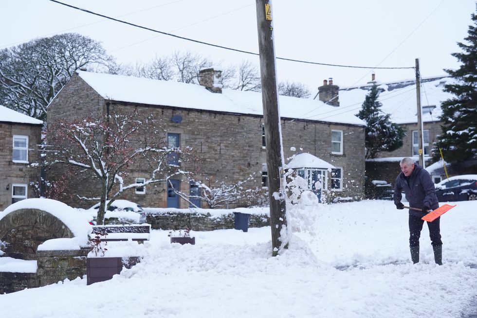 \u200bA man clears snow in Catton, Northumberland