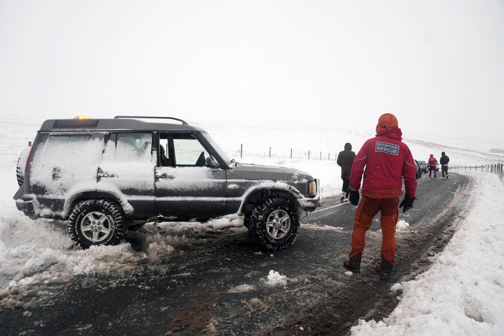 \u200bA member of a Mountain Rescue team after helping to clear cars from a snow drift near Ribblehead, in North Yorkshire