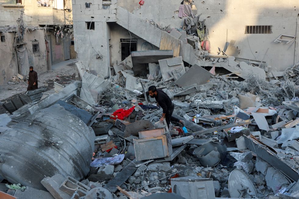 u200bA Palestinian man walks through the rubble at the site of an Israeli strike on a house in Gaza