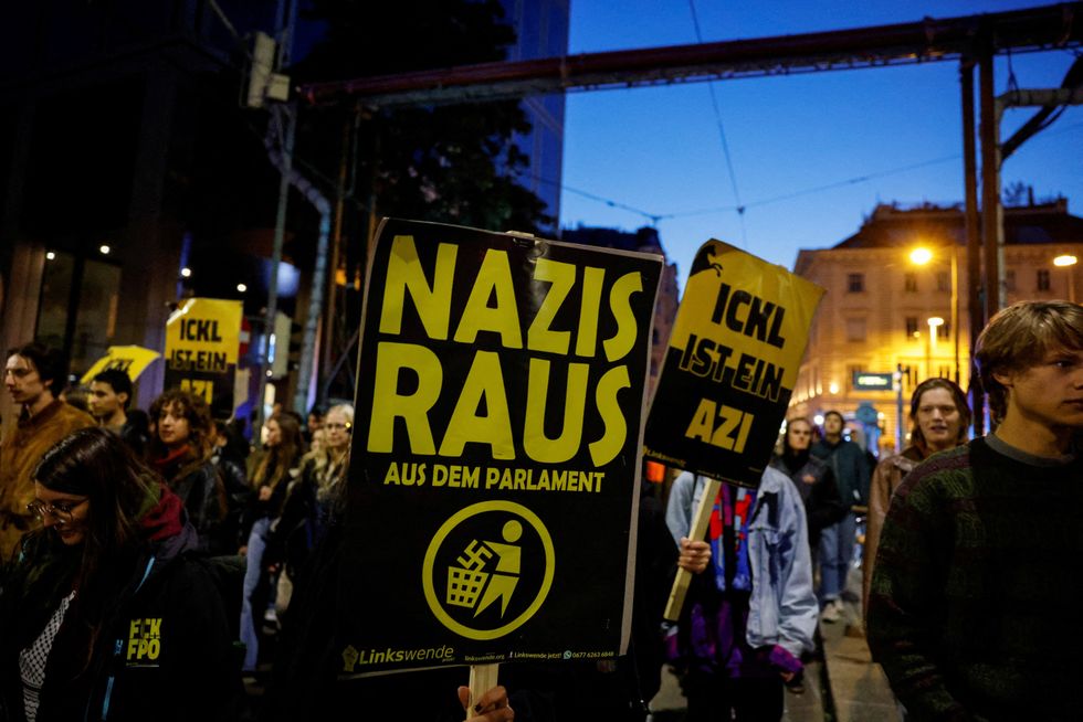 \u200bA person carries a placard that reads 'Nazis out of parliament', during a protest, after the first exit polls during the general election, in Vienna, Austria,