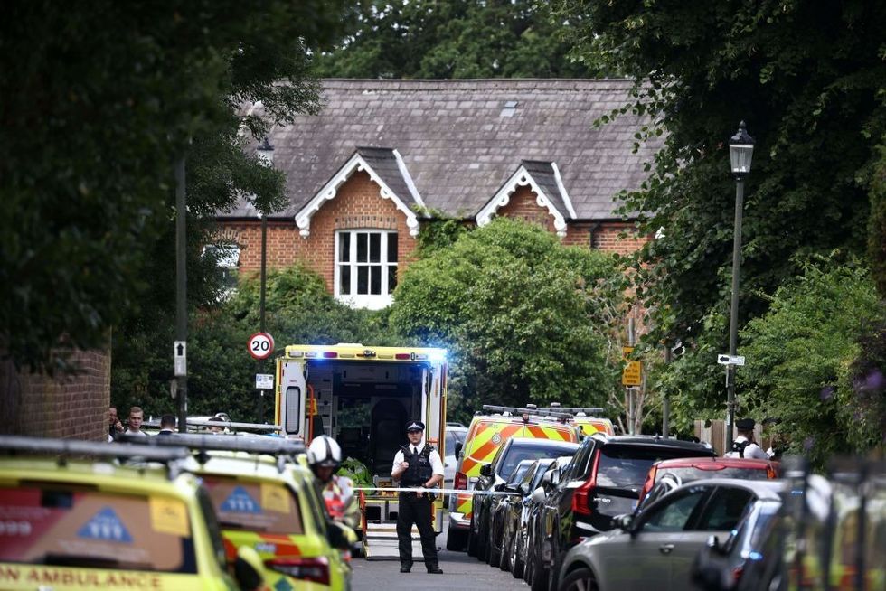 u200bA police officer stands guard next to an ambulance behind a cordon following a car collision at the private Study Prep girls' school in Wimbledon