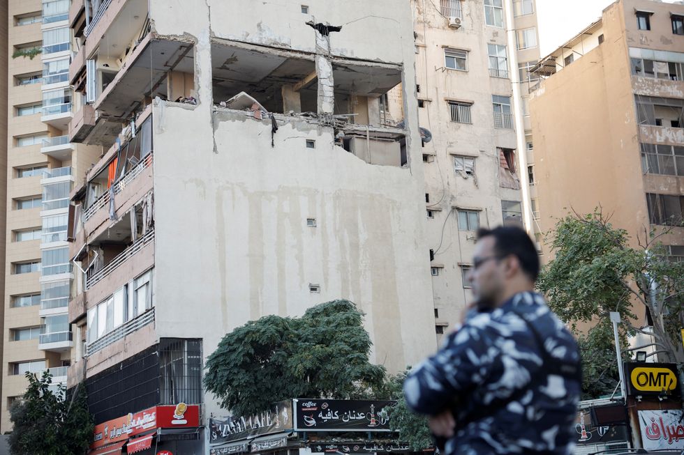 u200bA security personnel stands next to the buildings damaged in an Israeli strike, amid ongoing cross-border hostilities between Hezbollah and Israeli forces, in Kola, central Beirut