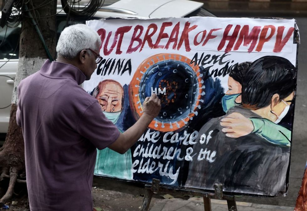 u200bAn art teacher paints a poster to raise awareness against the spread of the HMPV virus in Mumbai, India