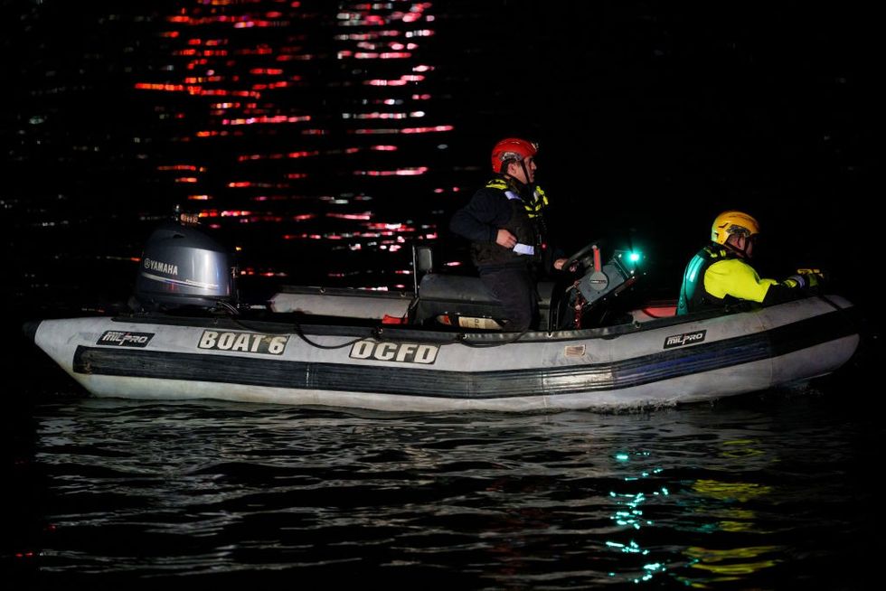 u200bAn emergency response team with Washington, DC Fire and EMS make their way to airplane wreckage in the Potomac River