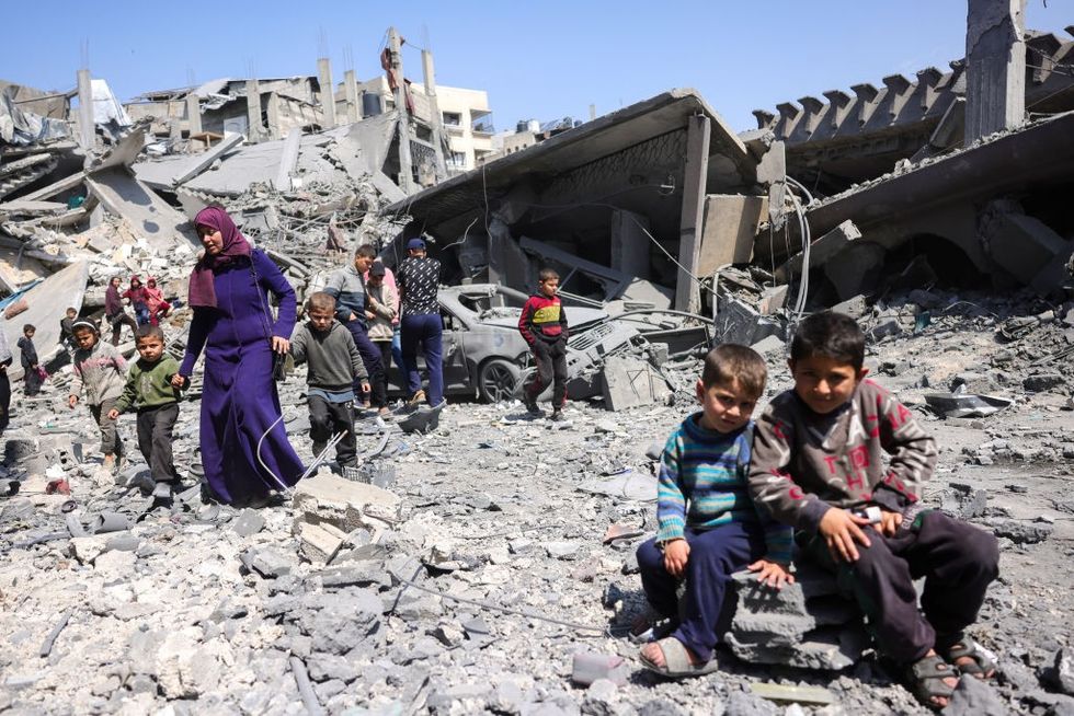 u200bChildren look on as people walk amid the rubble of a building destroyed in an overnight Israeli strike in Jabalia,