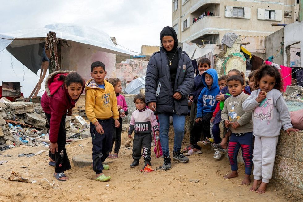 \u200bChildren play with marbles near destroyed buildings at the Shati camp for Palestinian refugees north of Gaza City