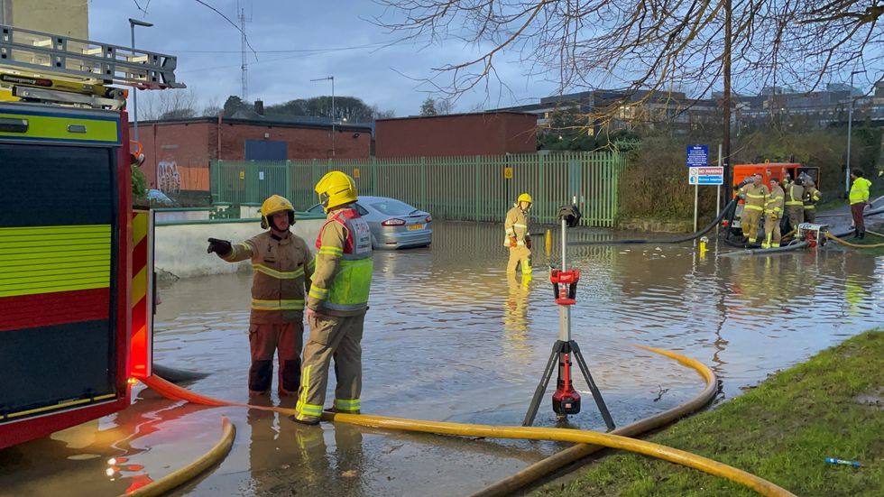 u200bFirefighters work to pump water away from flooded residential streets near Moat Park in Dundonald on the outskirts of Belfast.