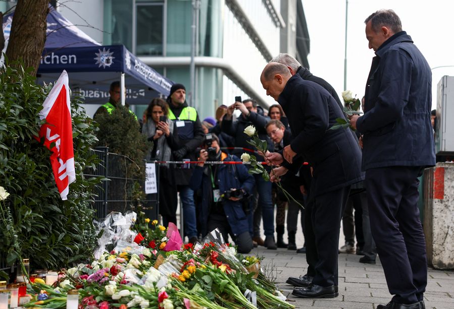 \u200bGerman Chancellor Olaf Scholz lays a flower next to Minister for Justice and Transport Volker Wissing, at a makeshift memorial for the victims of a suspected ramming attack