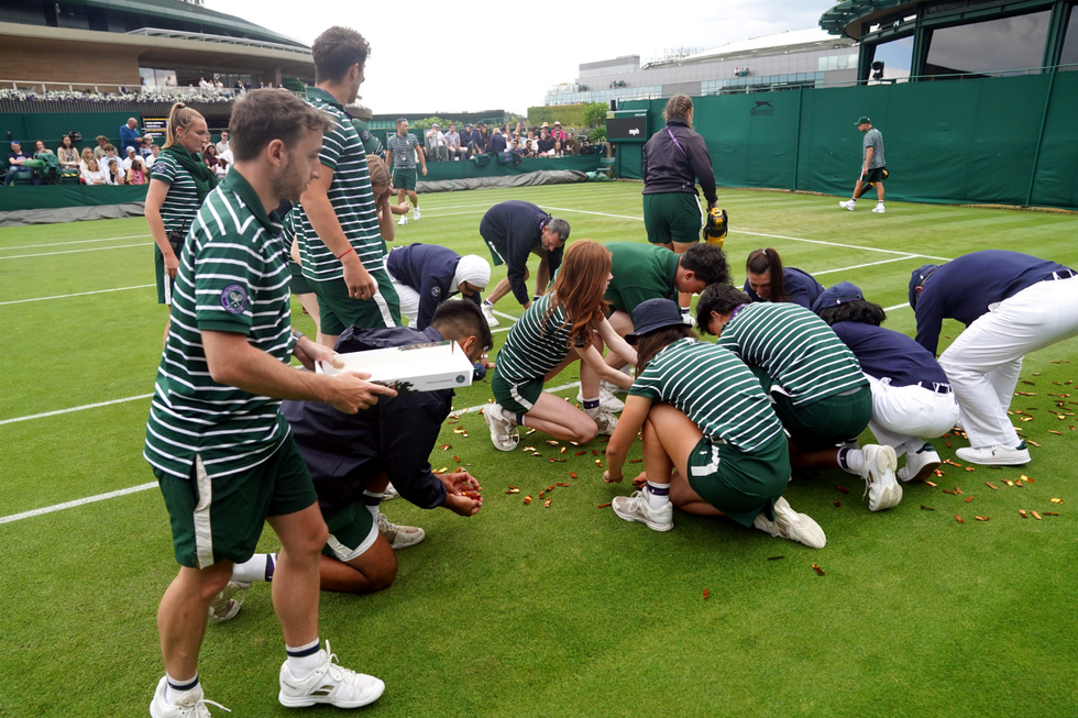 \u200bGround staff clear confetti from court 18 after the protest