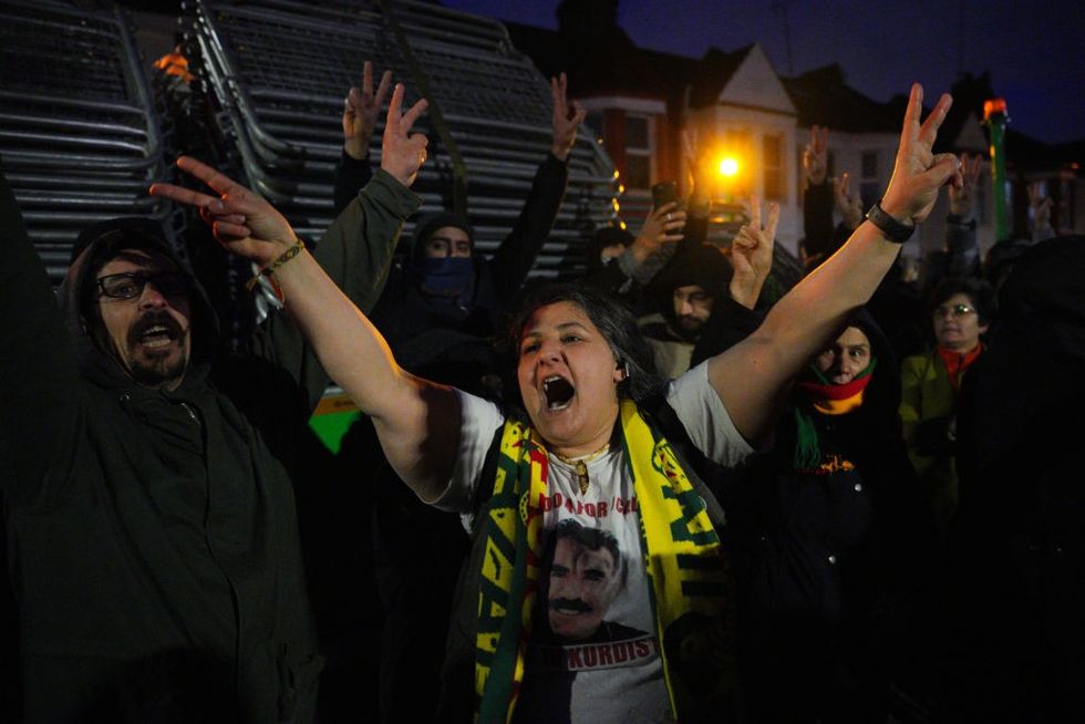 u200bKurdish people shout as they block barriers from being unloaded and used to stop access to a road leading to a Kurdish community centre