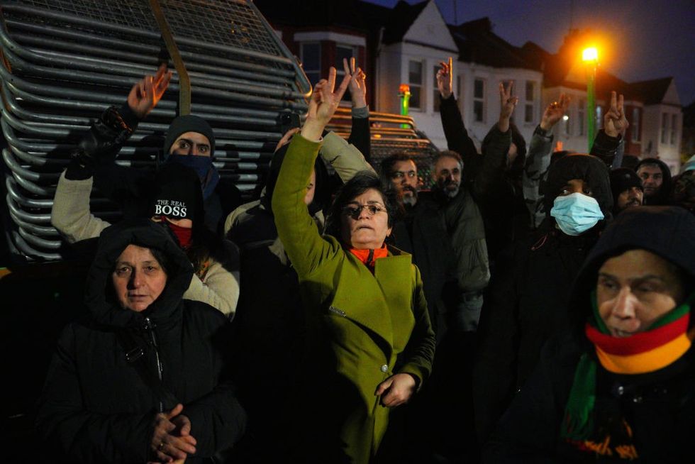 u200bKurdish people shout as they block barriers from being unloaded and used to stop access to a road leading to a Kurdish community centre