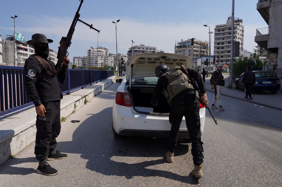 \u200bMembers of the Syrian security forces check a car as they battle against a nascent insurgency