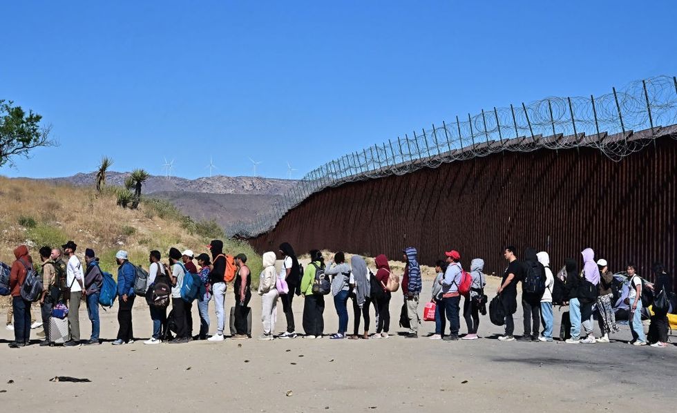 \u200bMigrants wait in line hoping for processing from Customs and Border Patrol agents